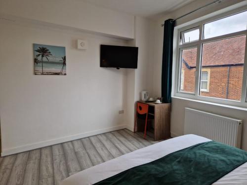 a bedroom with a bed and a window and a television at Crown House in Oxford
