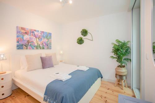 sypialnia z łóżkiem z obrazem na ścianie w obiekcie Liiiving in Porto - Boho Blue Home w Porto