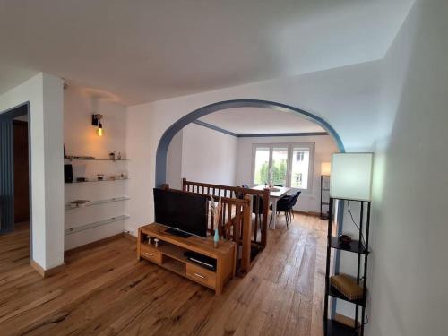 - un salon avec une table et une télévision dans l'établissement Duplex près des Thermes avec jardin, à Évian-les-Bains