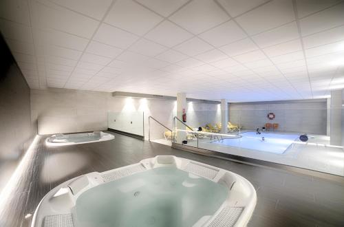 a large bathroom with a bath tub and a large tub at Ohtels Villa Dorada in Salou