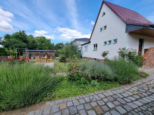a garden in front of a white house at Ferien Oase am BER in Schönefeld
