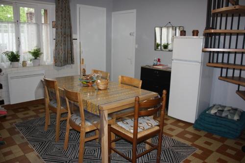 uma cozinha com uma mesa e cadeiras e um frigorífico em La Gâtinaise em Châtillon-Coligny