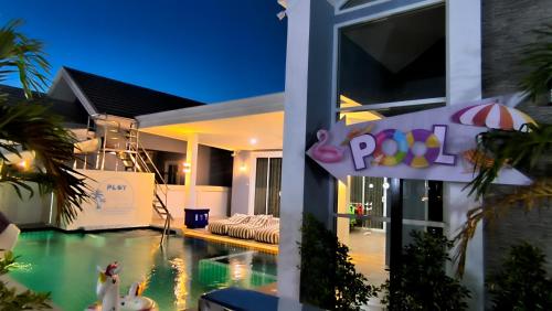 una casa con piscina por la noche en พลอยพูลวิลล่า ชะอำ 3 Ploy Poolvilla Cha-am 3, en Cha Am