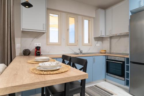 a kitchen with a wooden table and blue cabinets at Helicon Luxury Villas in Limenas