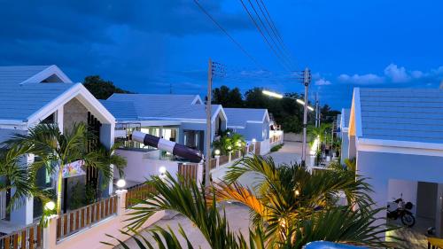 una calle de la ciudad por la noche con casas blancas en พลอยพูลวิลล่า ชะอำ 3 Ploy Poolvilla Cha-am 3, en Cha Am
