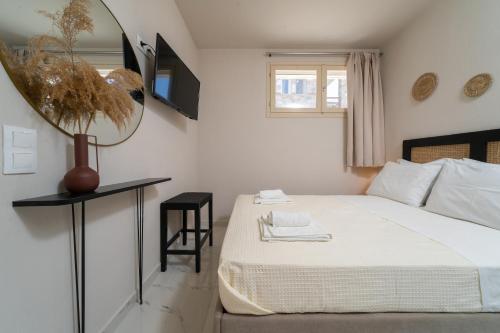 a white bedroom with a bed and a mirror at Helicon Luxury Villas in Limenas