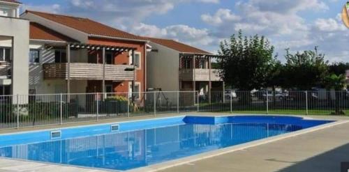 a swimming pool in front of a building at Rêve de Bisca Appartement spacieux avec jardin privatif piscine et parking privés in Biscarrosse