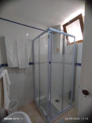 a shower with a glass door in a bathroom at Apartamentos das Avós-Bélise in Nazaré