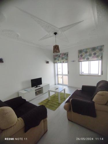 a living room with two couches and a tv at Apartamentos das Avós-Bélise in Nazaré