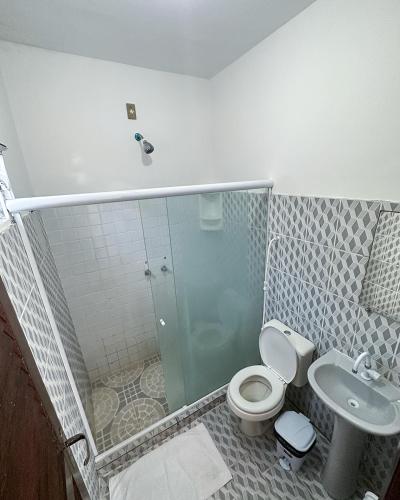 a bathroom with a shower and a toilet and a sink at Hotel Marujo in Morro de São Paulo