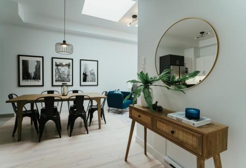 a dining room with a table and a mirror at Welcoming and Light Filled 2bdr Apartment in Montréal