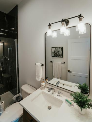 a bathroom with a sink and a tub and a mirror at Welcoming and Light Filled 2bdr Apartment in Montréal