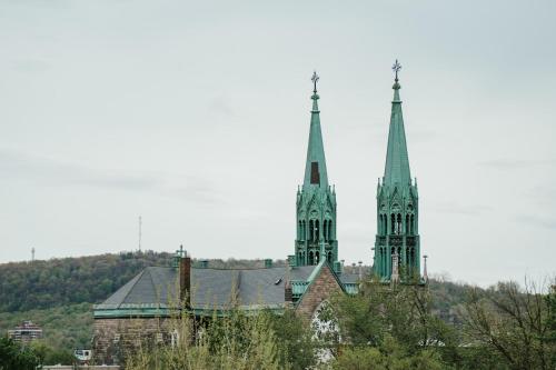 two towers of a building with trees in front of it at New Spacious and Cozy 2bdr Apartment in Montréal