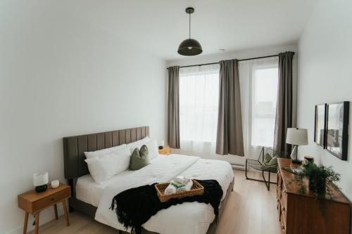a bedroom with a large white bed and windows at New Spacious and Cozy 2bdr Apartment in Montréal