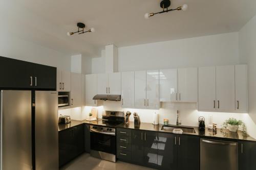 a kitchen with white cabinets and a black refrigerator at New Spacious and Cozy 2bdr Apartment in Montréal