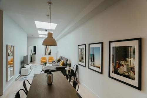 a living room with a table and some pictures on the wall at New Spacious and Cozy 2bdr Apartment in Montréal