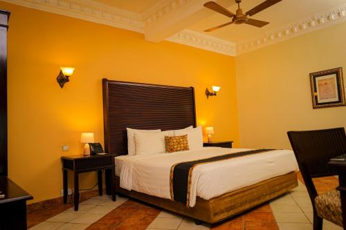 sypialnia z łóżkiem z żółtymi ścianami w obiekcie Colosseum Boutique Hotel & Spa w mieście Dar es Salaam