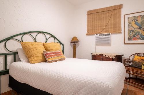 a bedroom with a bed with yellow pillows at Beach Pad w Patio, walk to everything! GEN AC - 20 Down in San Juan