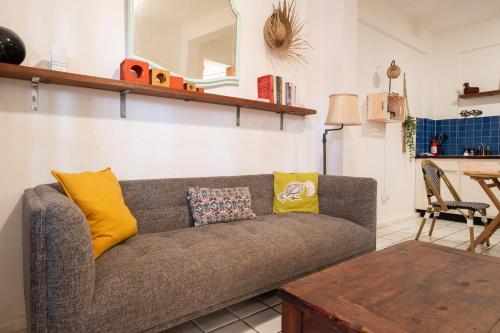 a living room with a gray couch with yellow pillows at Beach Pad w Patio, walk to everything! GEN AC - 20 Down in San Juan