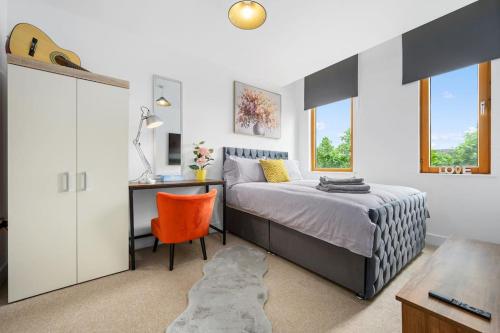 a bedroom with a bed and a desk and a chair at Central Piccadilly Luxury Three Bedroom Apartment in Manchester
