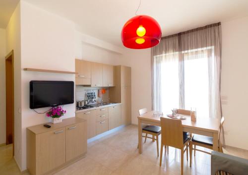 una cucina e una sala da pranzo con tavolo e TV di Iria Residence a Torre dell'Orso