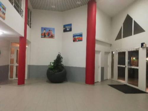 une pièce avec deux colonnes rouges et une plante en pot dans l'établissement Appartement climatisé avec vue mer et piscine, à Sète