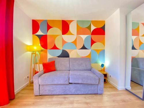 - un salon avec un canapé et un mur coloré dans l'établissement Studio Luxury Toîts du Soleil By SCLS Locations, à Cannes