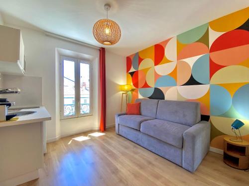 - un salon avec un canapé et un mur coloré dans l'établissement Studio Luxury Toîts du Soleil By SCLS Locations, à Cannes