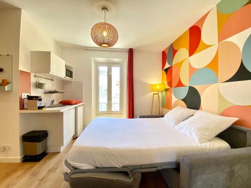 - une chambre avec un grand lit et un mur coloré dans l'établissement Studio Luxury Toîts du Soleil By SCLS Locations, à Cannes