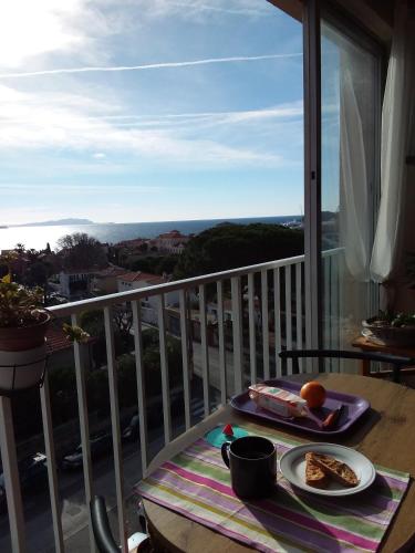 une table avec une assiette de nourriture sur un balcon dans l'établissement Belle vue mer pour ce T3 à la ciotat, à La Ciotat