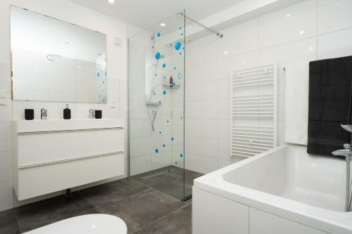 a white bathroom with a shower and a sink at Luxe Villa Texel 8-10 personen met Sauna Krim 95 in De Cocksdorp