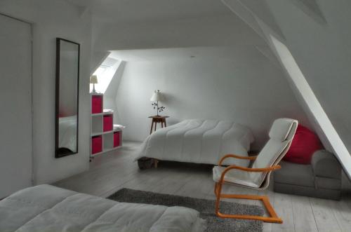 1 dormitorio con 1 cama y 1 silla en una habitación en Maison de 4 chambres avec piscine privee et wifi a Saint Germain du Pert a 5 km de la plage, en Saint-Germain-du-Pert