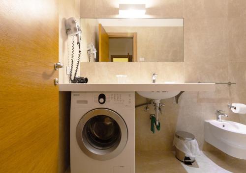 a bathroom with a washing machine and a sink at Iria Residence in Torre dell'Orso