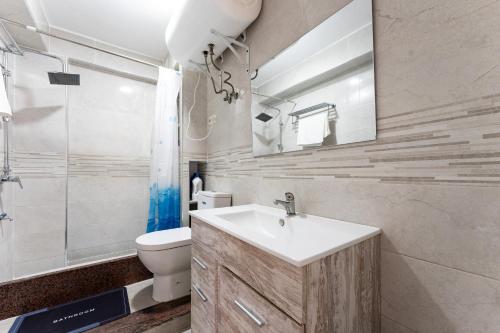a bathroom with a sink and a toilet and a mirror at Casa de Bella Fuengirola in Fuengirola