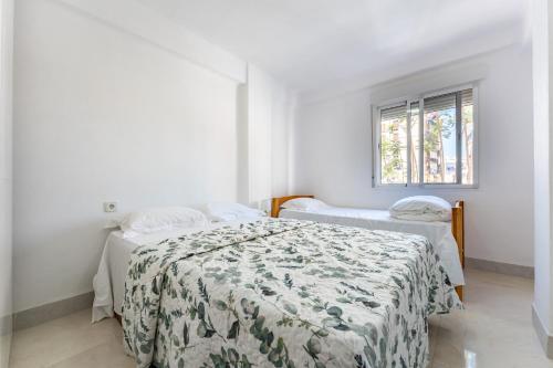 a white room with two beds and a window at Casa de Bella Fuengirola in Fuengirola