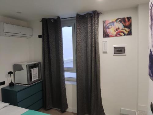 a bedroom with a window and a bed with curtains at Siderno Small in Siderno Marina