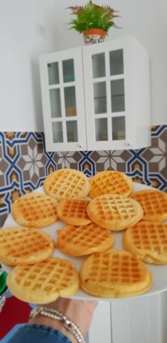a person holding a plate of waffle cookies at Signora Irma in Margherita di Savoia