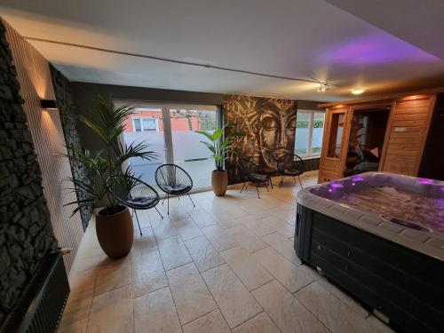 a large room with a hot tub and plants at Ostfriesland Ferien Villa - 24 Personen - Sauna, Whirlpool , Kino, und Bar in Backemoor