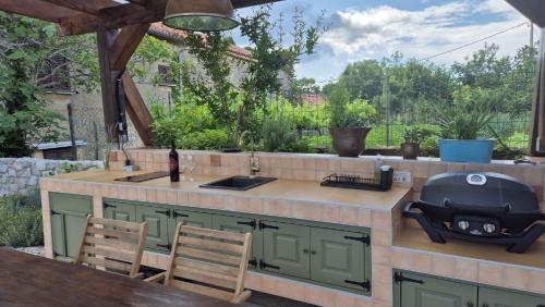 an outdoor kitchen with a grill on a patio at Bonvivan House in Diminići