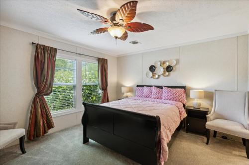 una camera con letto e ventilatore a soffitto di Pink Flamingo House a Cocoa