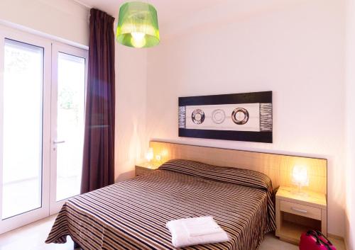 a bedroom with a bed and a large window at Iria Residence in Torre dell'Orso