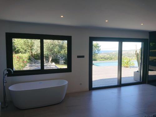 La salle de bains est pourvue d'une baignoire et de fenêtres avec vue. dans l'établissement Villa Cassis Vue mer et vignes, à Cassis