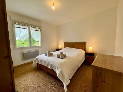 une chambre avec un lit blanc et une fenêtre dans l'établissement L'Appart du Lac de Gérardmer - Beau & spacieux, à Gérardmer