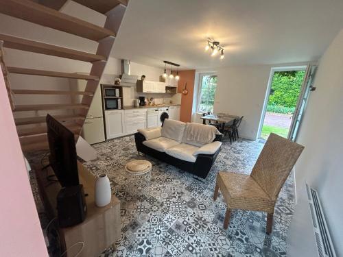 un salon avec un canapé et une télévision dans l'établissement Le Pré Lassé, à Soulangy