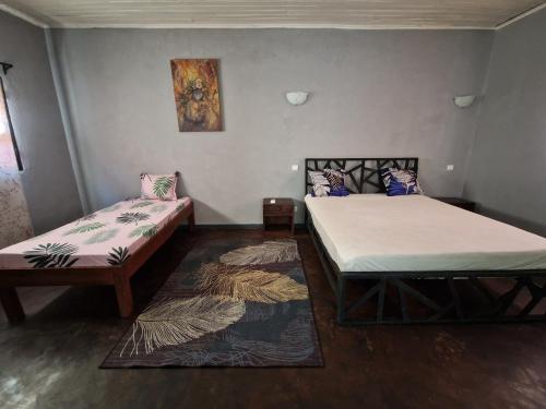 諾西貝的住宿－Bungalow chez Mouch Nosy-Be 4，一间设有两张床的房间和一张地毯
