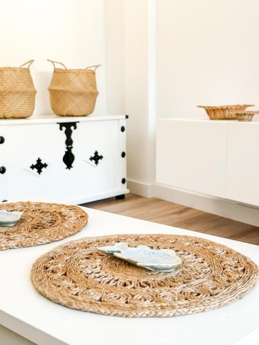 a white counter with two plates on a table at Apartamento Luar by ALÔGA in Cee