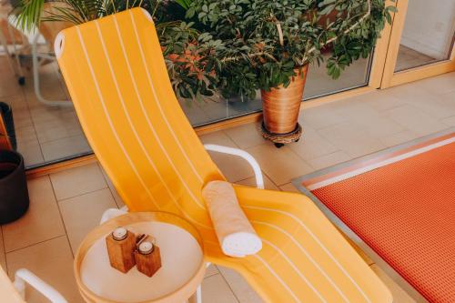 a yellow chair with a table in a room at Lindenhaus in Zwiesel
