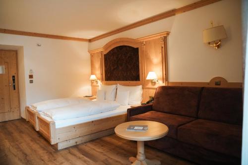 a hotel room with a bed and a couch at Engels Park in Vipiteno