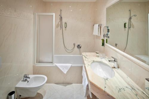 a white bathroom with a sink and a shower at Engels Park in Vipiteno