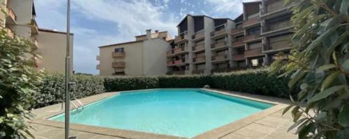 une grande piscine devant un immeuble dans l'établissement Le Bonamour sur le port de Capbreton, à Capbreton